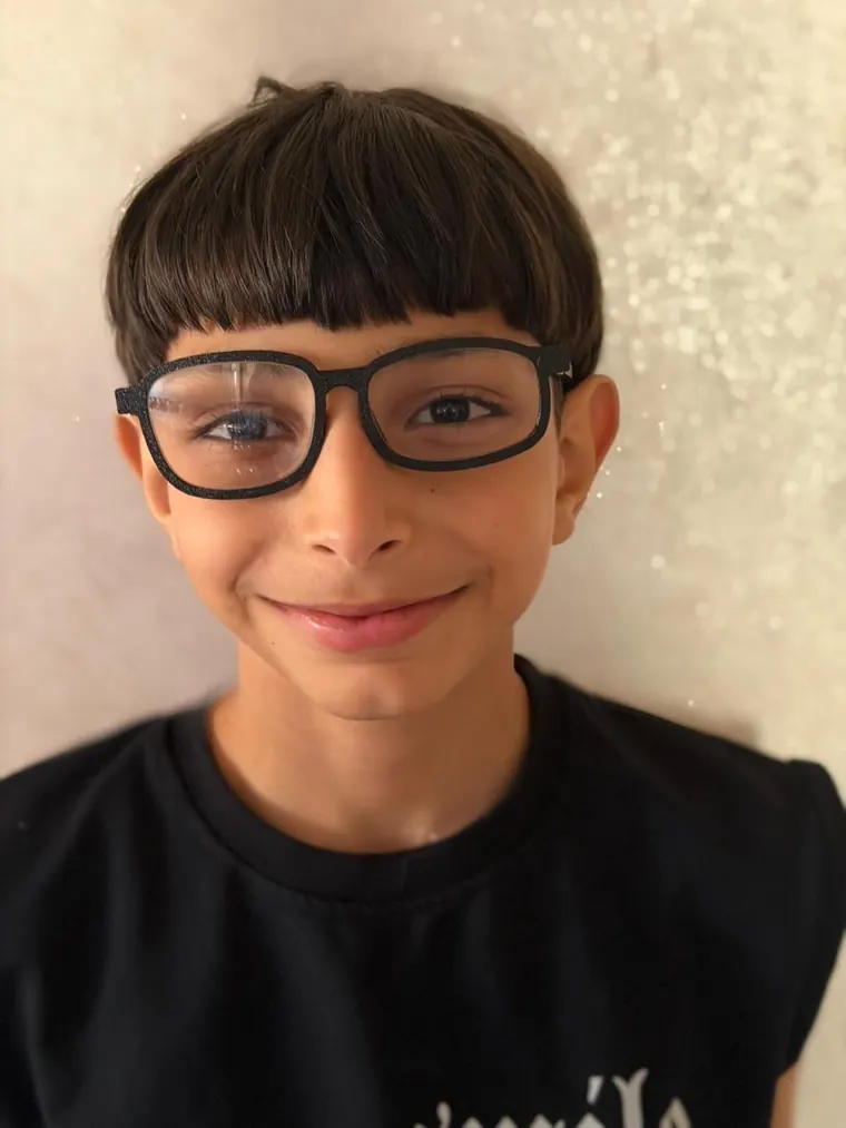 Un jeune garçon souriant avec ses nouvelles lunettes